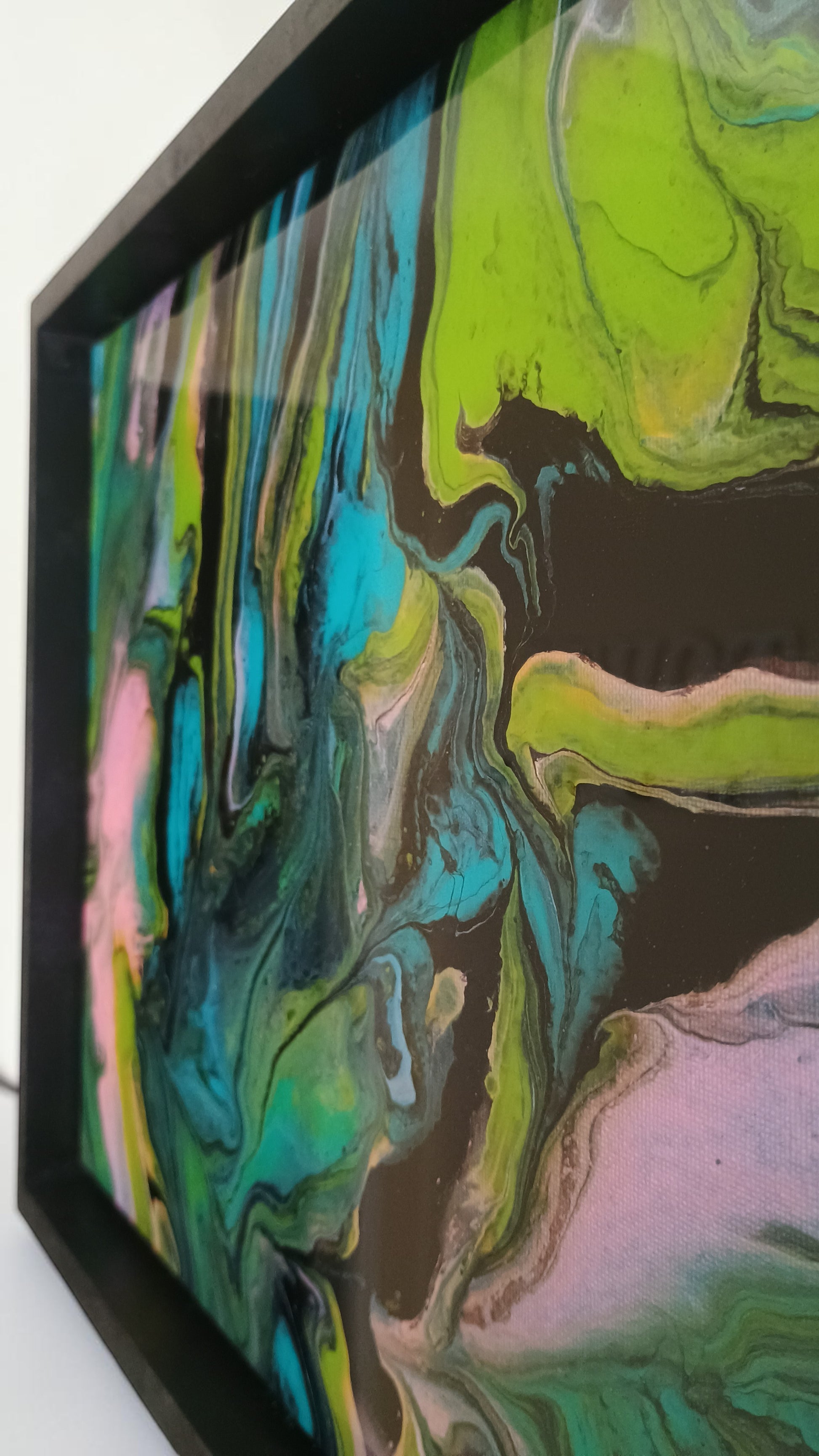 Abstract art piece with vibrant colors in a black frame.