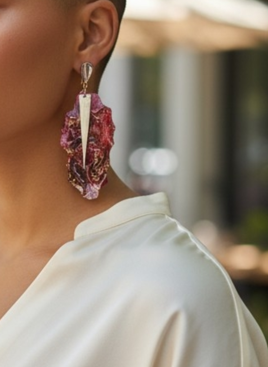 Close-up of a person wearing a colorful earring with a blurred background