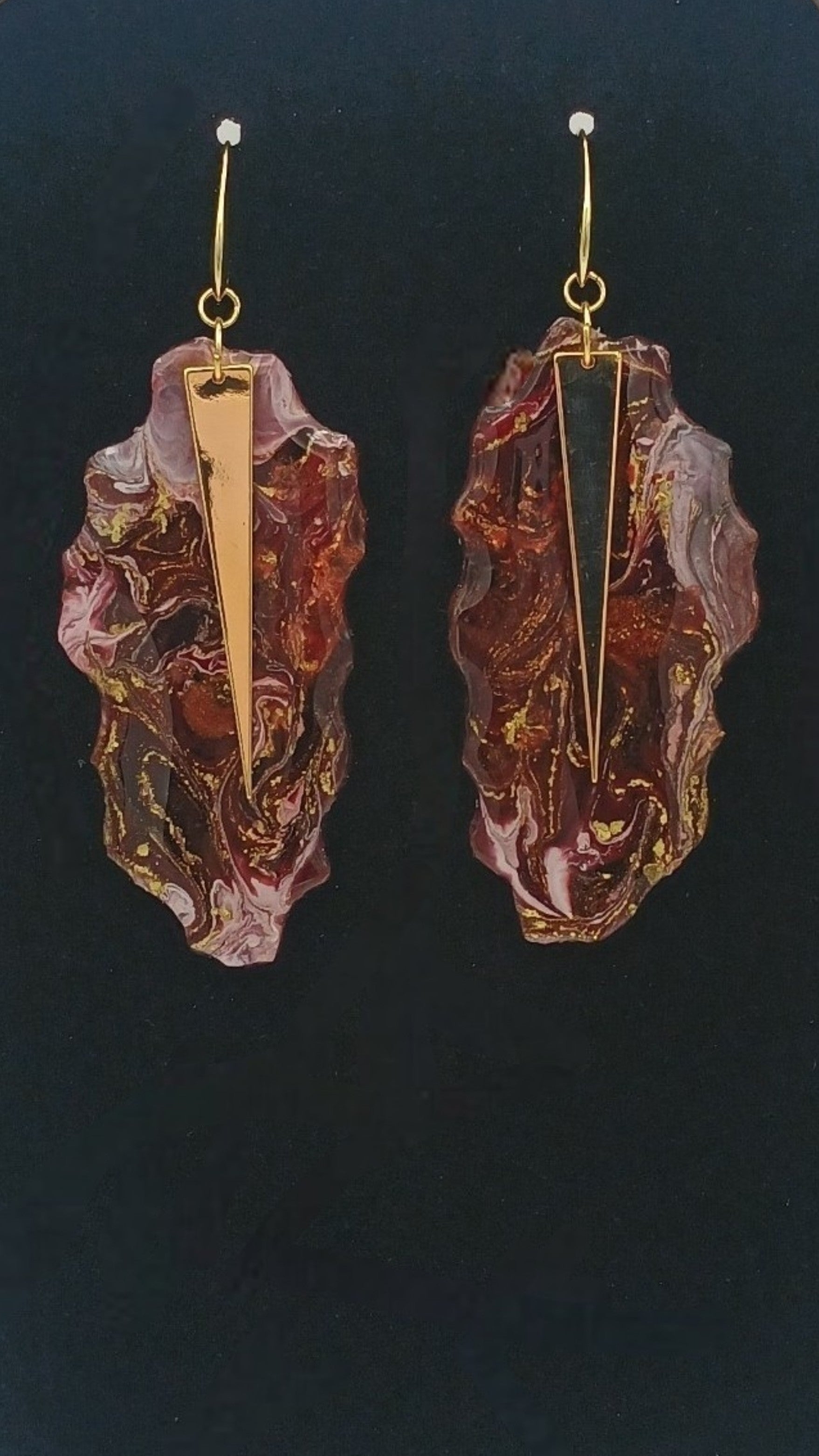 Pair of earrings with marbled design and gold accents on a dark background Gotta Have It Design