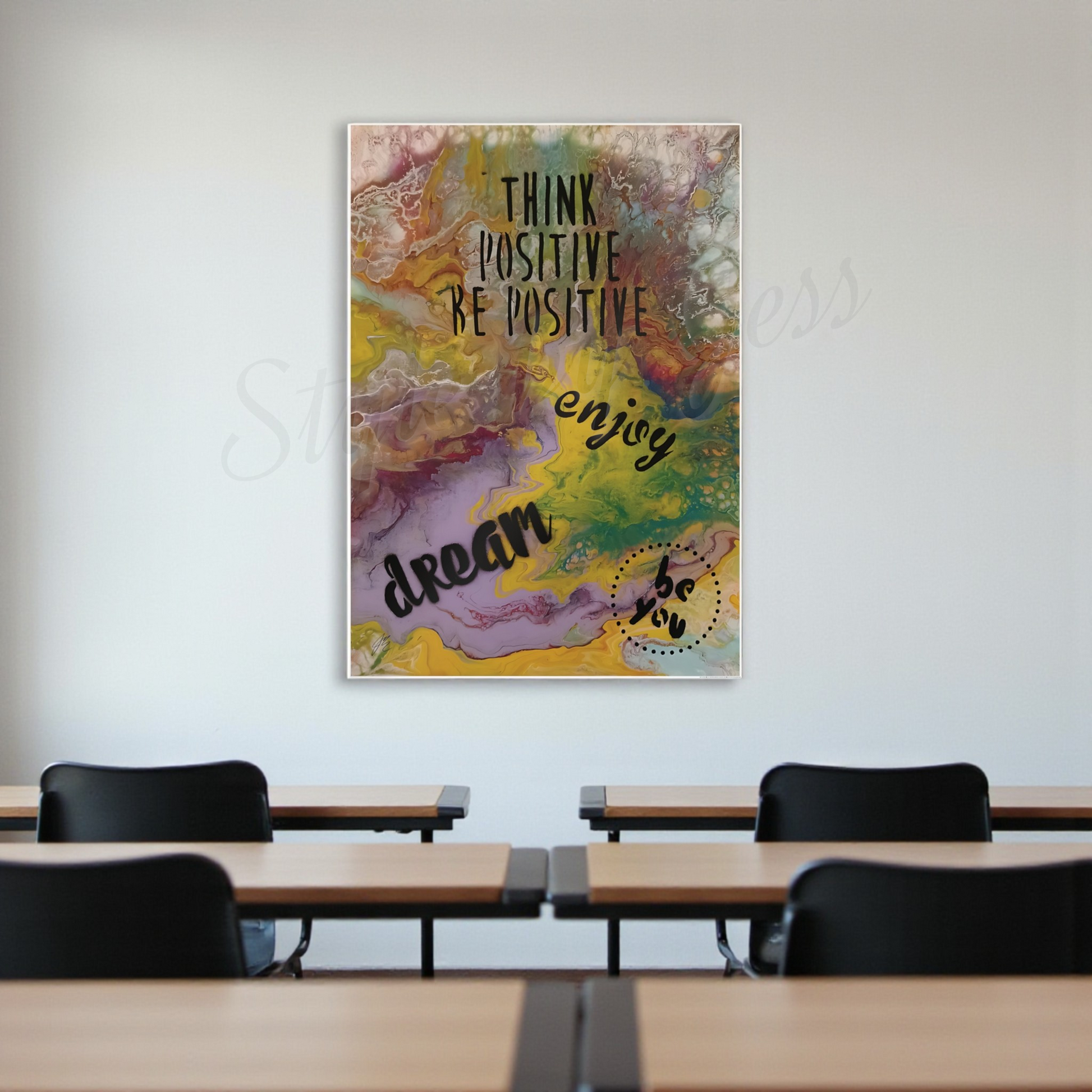 Colorful motivational poster on a wall above a classroom setup with desks and chairs.
