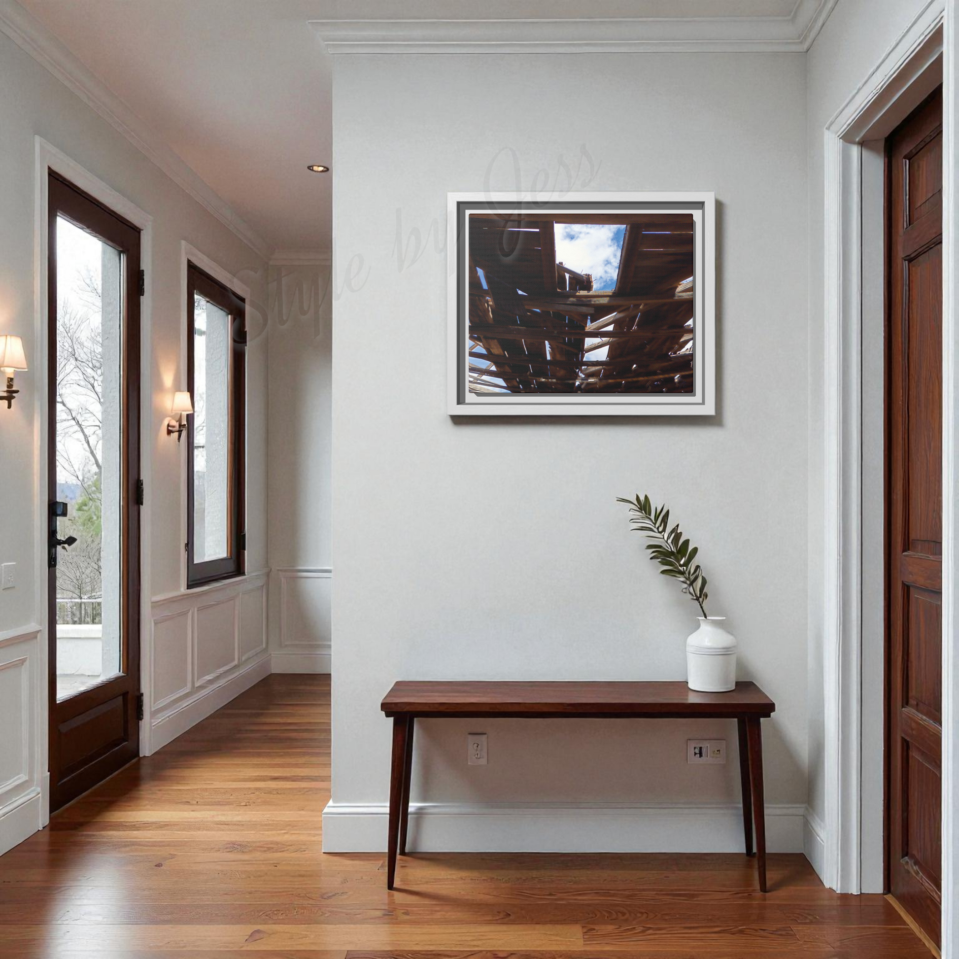 Foyer with wooden bench, plant, and framed picture on white wall