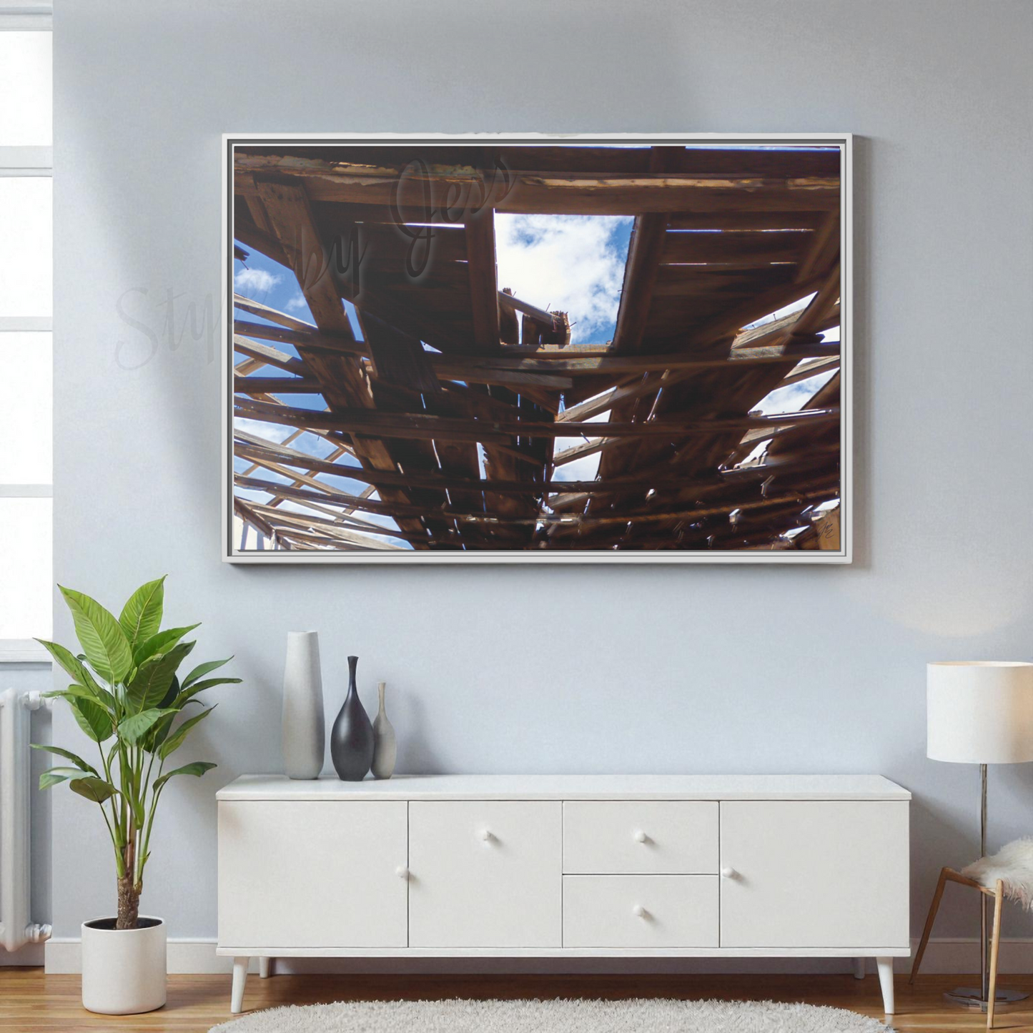 Modern living room with a large framed picture on the wall above a white cabinet.