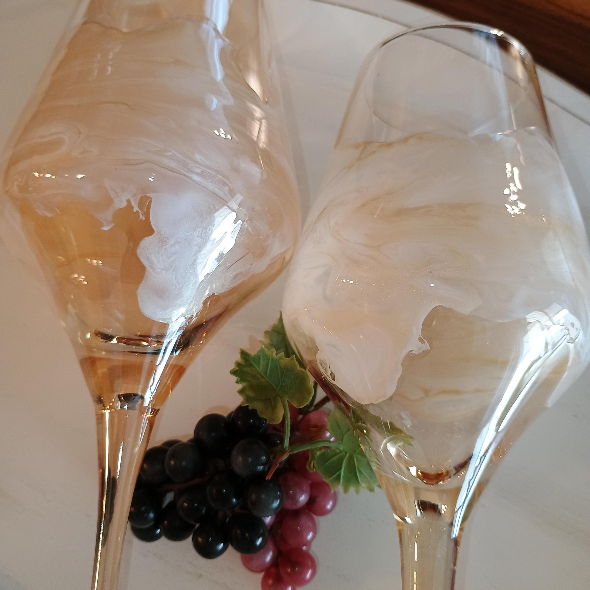 Two wine glasses and a cluster of grapes on a white plate.