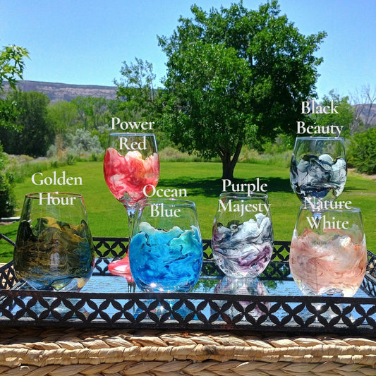 Set of colorful wine glasses with names on a table outdoors by Style By Jess
