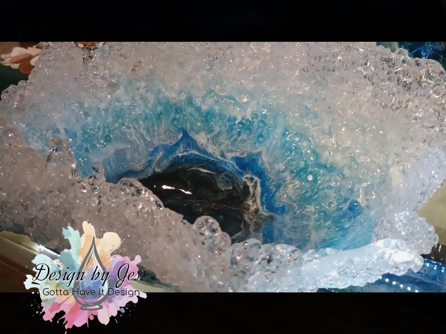 Close-up of a crystal looking bowl with blue and white patterns similar to was crashing at the top of the bowl.