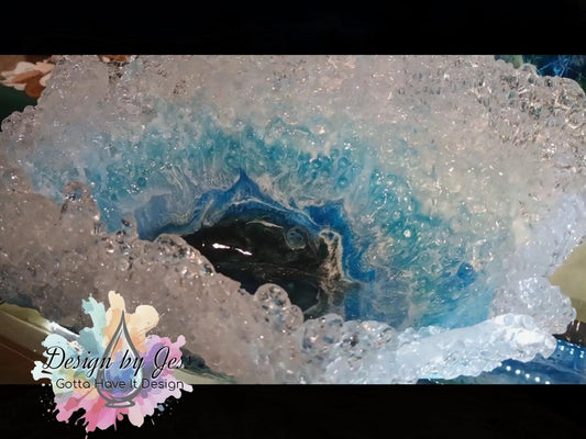 Close-up of a crystal looking bowl with blue and white patterns similar to was crashing at the top of the bowl.