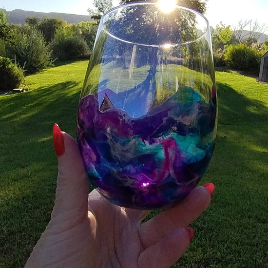 Video of an abstract art stemless wine glass with purple and teal  handmade design a Style By Jess. 