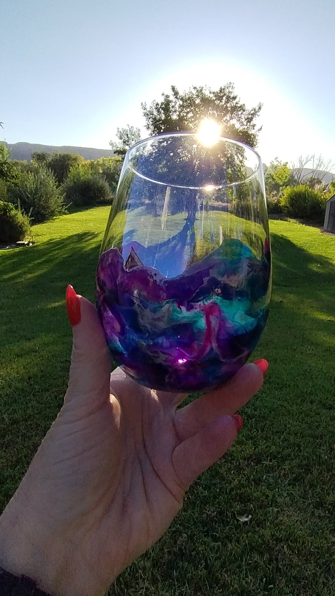 Video of an abstract art stemless wine glass with purple and teal  handmade design a Style By Jess. 
