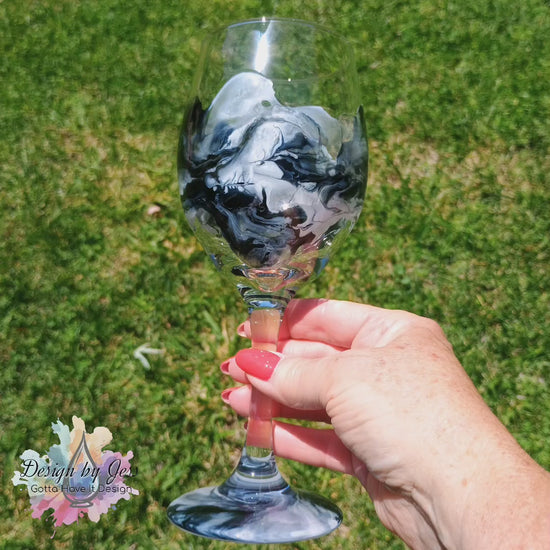 Video of a wine glass decorated with a marble like resin art a Style by Jess.
