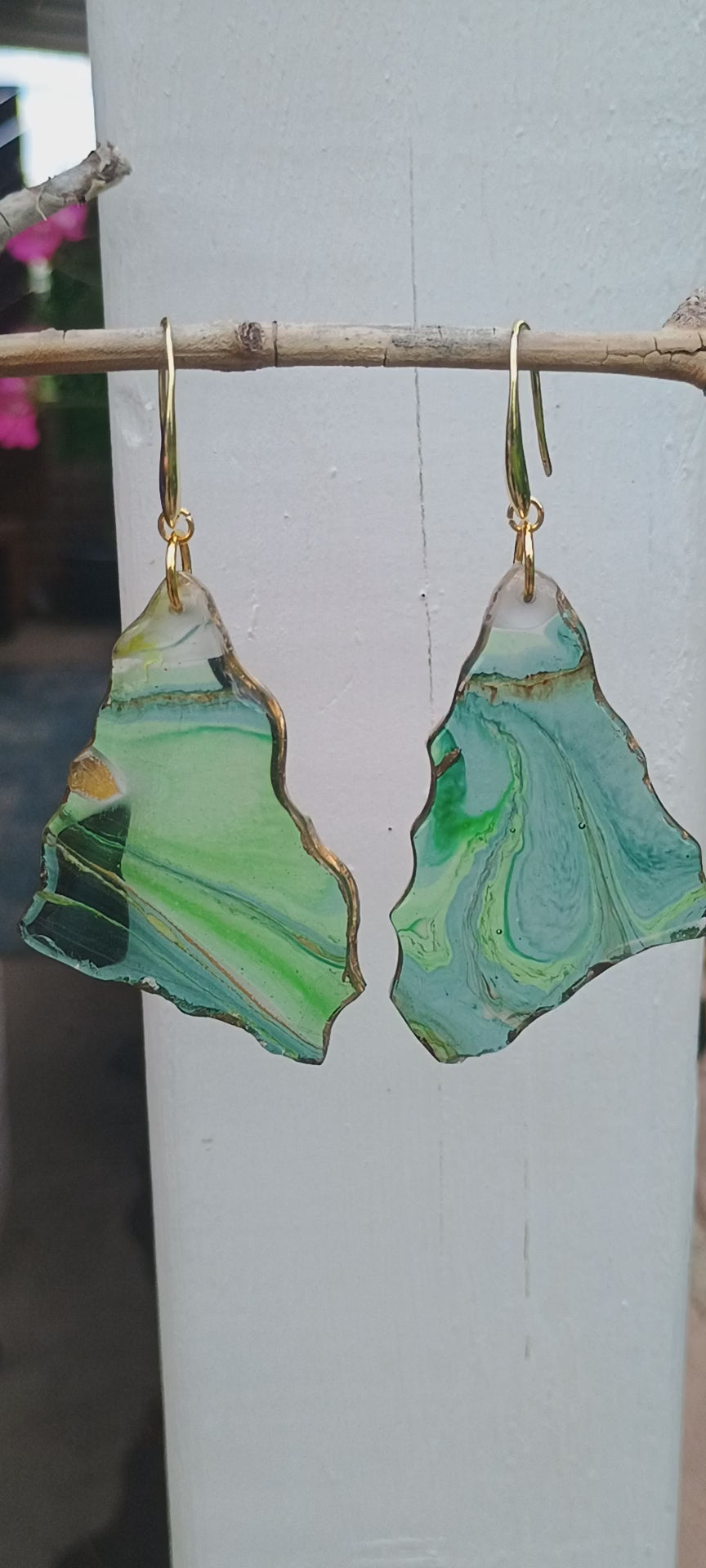 Video of abstract art statement earrings created with resin displaying a geode style with snow capped mountain white tops.  Video is filmed with a white background and pans to a nature setting.  A Style By Jess at Gotta Have It Design. 