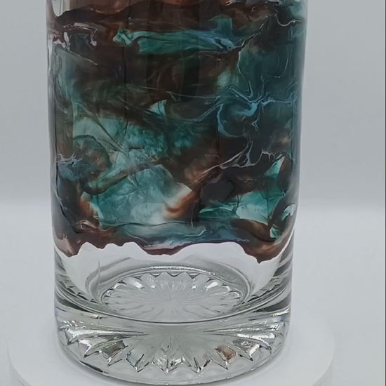 Video of a large glass mug with handmade resin art swirling about the glass in a mesmerizing fashion. The mug is spinning to show off the different effects from every angle.  This abstract art was created by Jess a Style by Jess creation made perfect for gift giving.