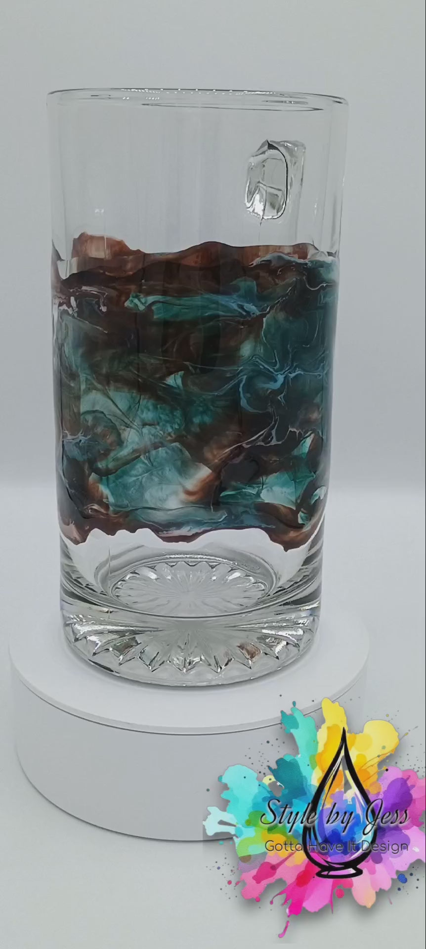 Video of a large glass mug with handmade resin art swirling about the glass in a mesmerizing fashion. The mug is spinning to show off the different effects from every angle.  This abstract art was created by Jess a Style by Jess creation made perfect for gift giving.
