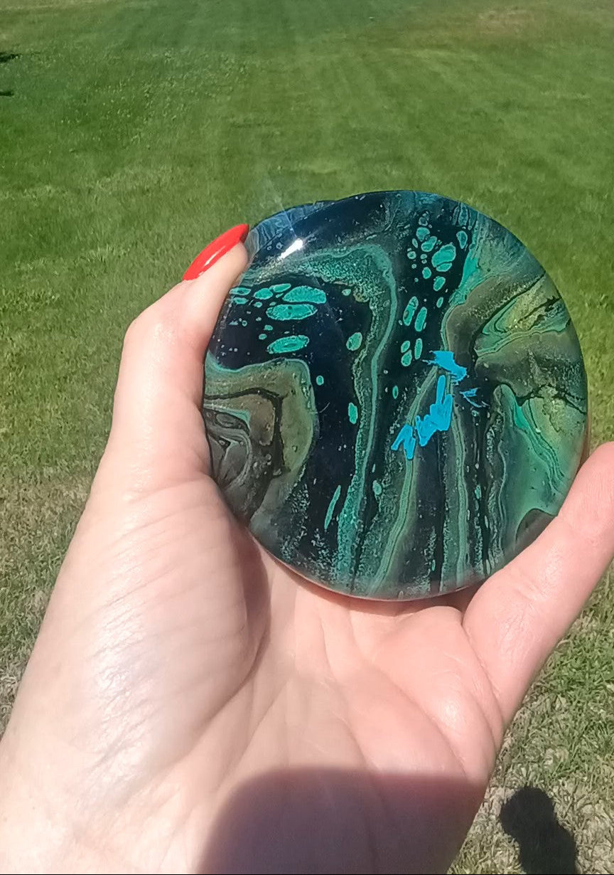 Image of the bottom of a abstract art green and black vase.