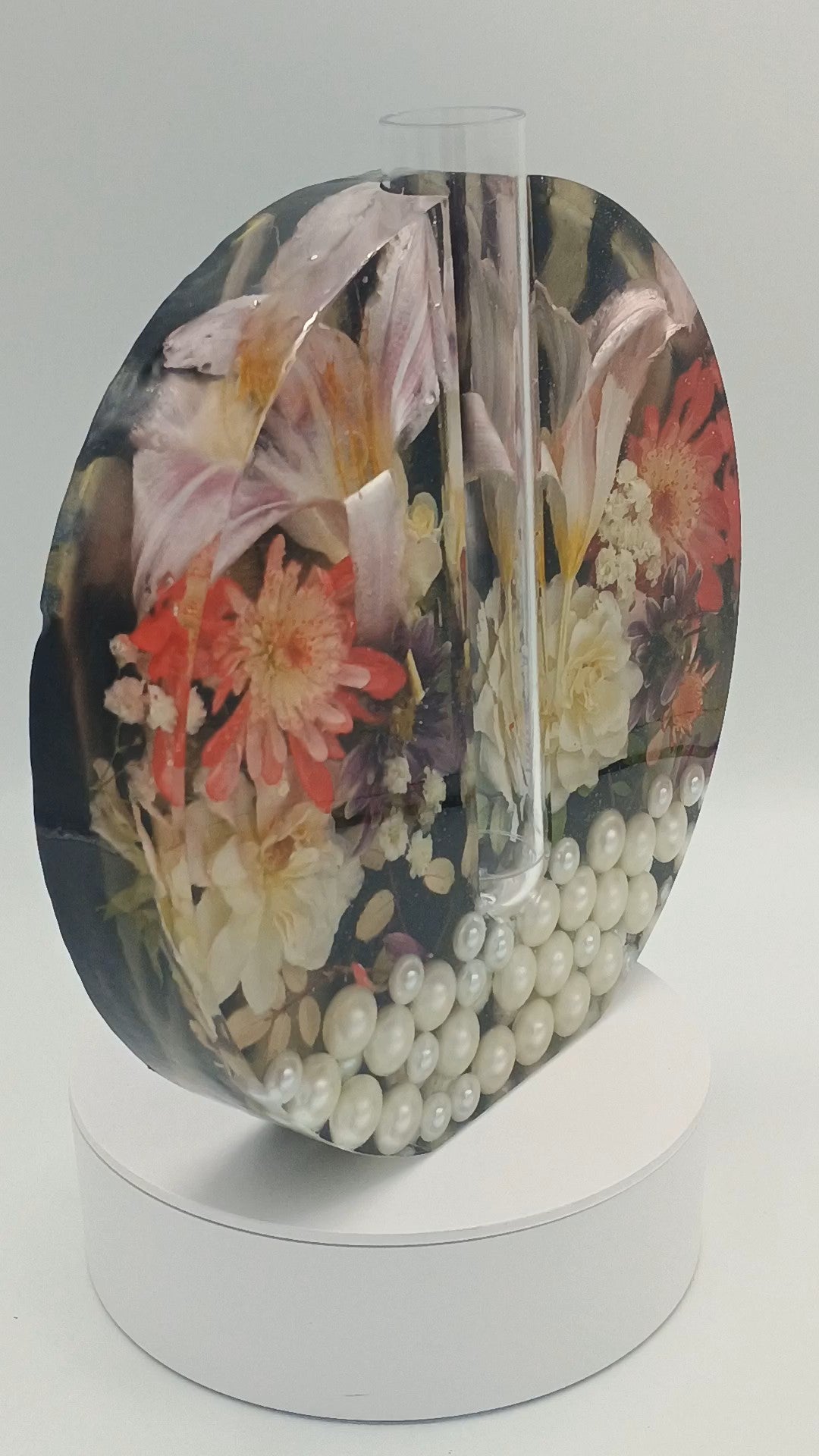 Decorative flower vase with floral design and pearls on a white stand