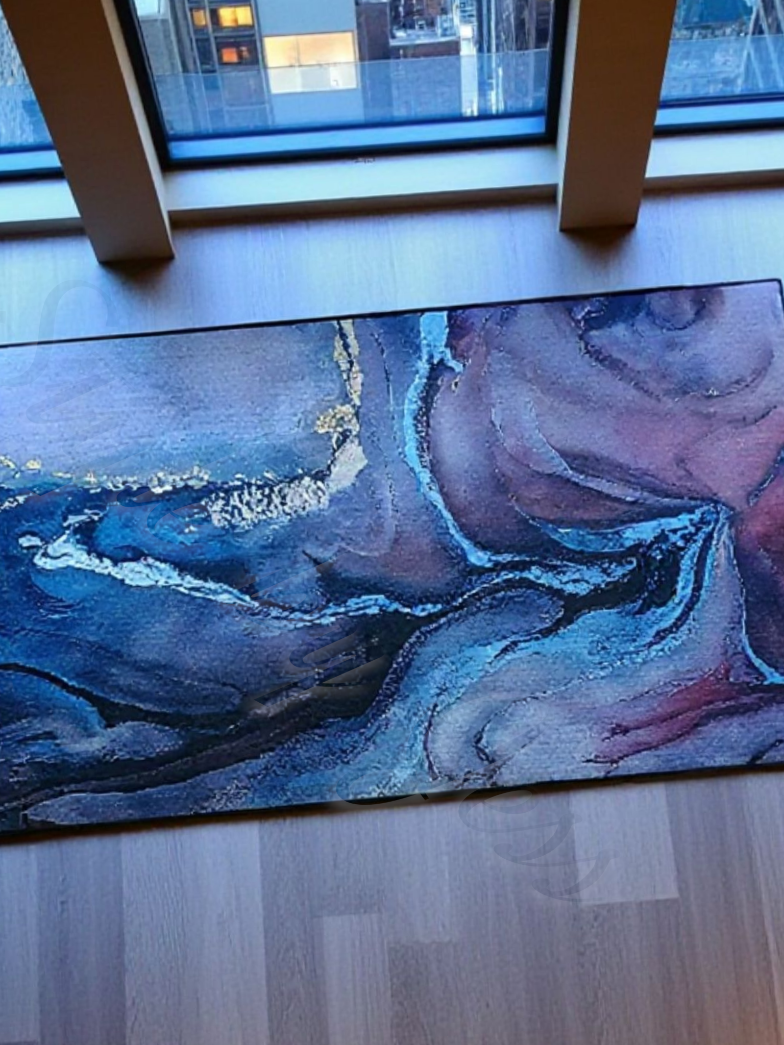 Abstract blue rug on a wooden floor with a window in the background area rug