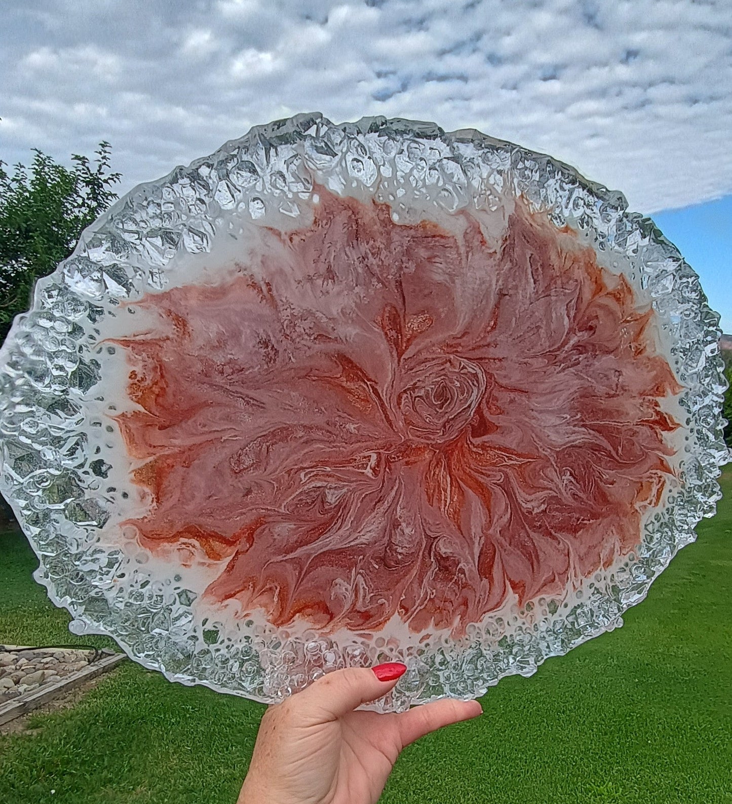Handmade resin serving platter with rose floral swirl design and crystal-effect edges displayed on a white marble kitchen island — oversized 18x13 food-safe resin art charcuterie board, one of a kind home decor gift by Style By Jess at Gotta Have It Design 