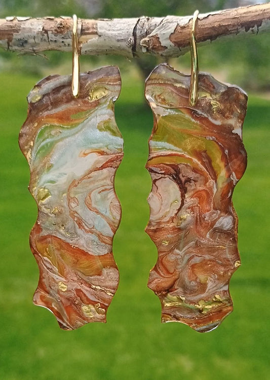 Marbled brown large dangle earrings handmade resin hanging from a branch with a blurred green background a Style By Jess at Gotta Have It Design