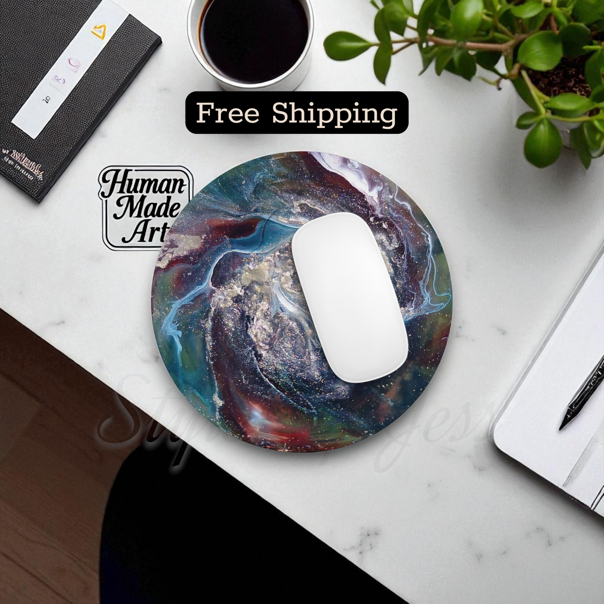 Colorful mouse pad with a swirling design on a desk with a cup of coffee and plant a Style By Jess