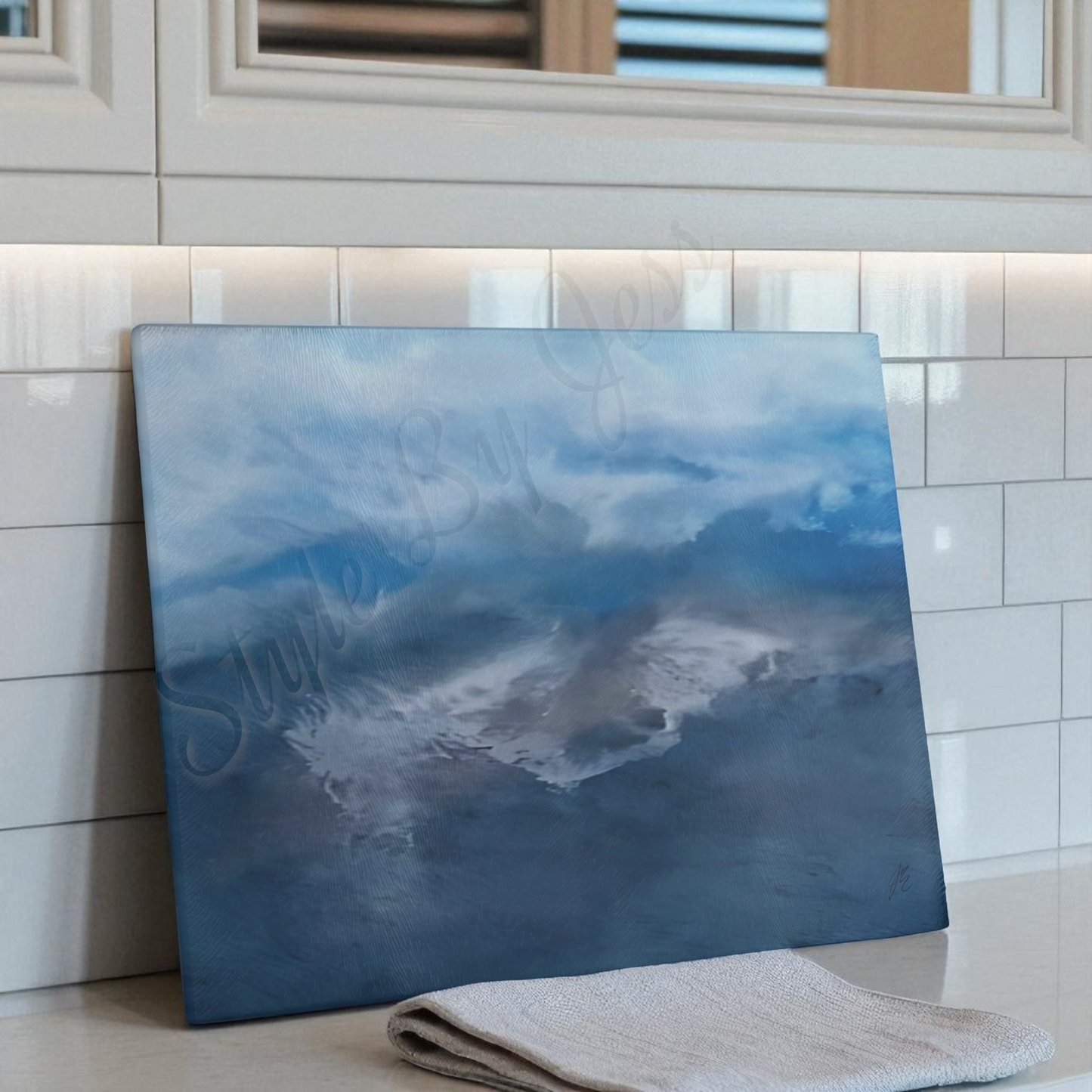 Blue sky glass cutting board propped up on back splash of kitchen counter
