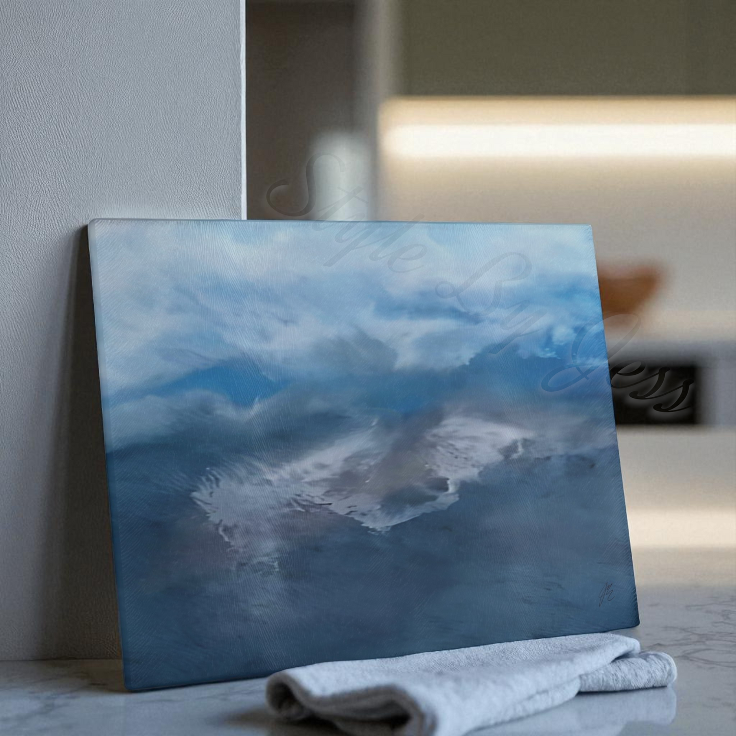 Landscape custom abstract blue cutting board leaning on a wall with a hand towel in front of it.