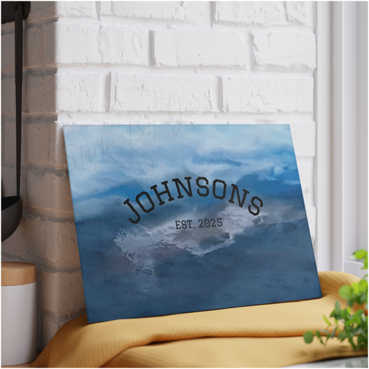 Image of personalization option of glass cutting board with blue abstract design, placed against a white brick wall.