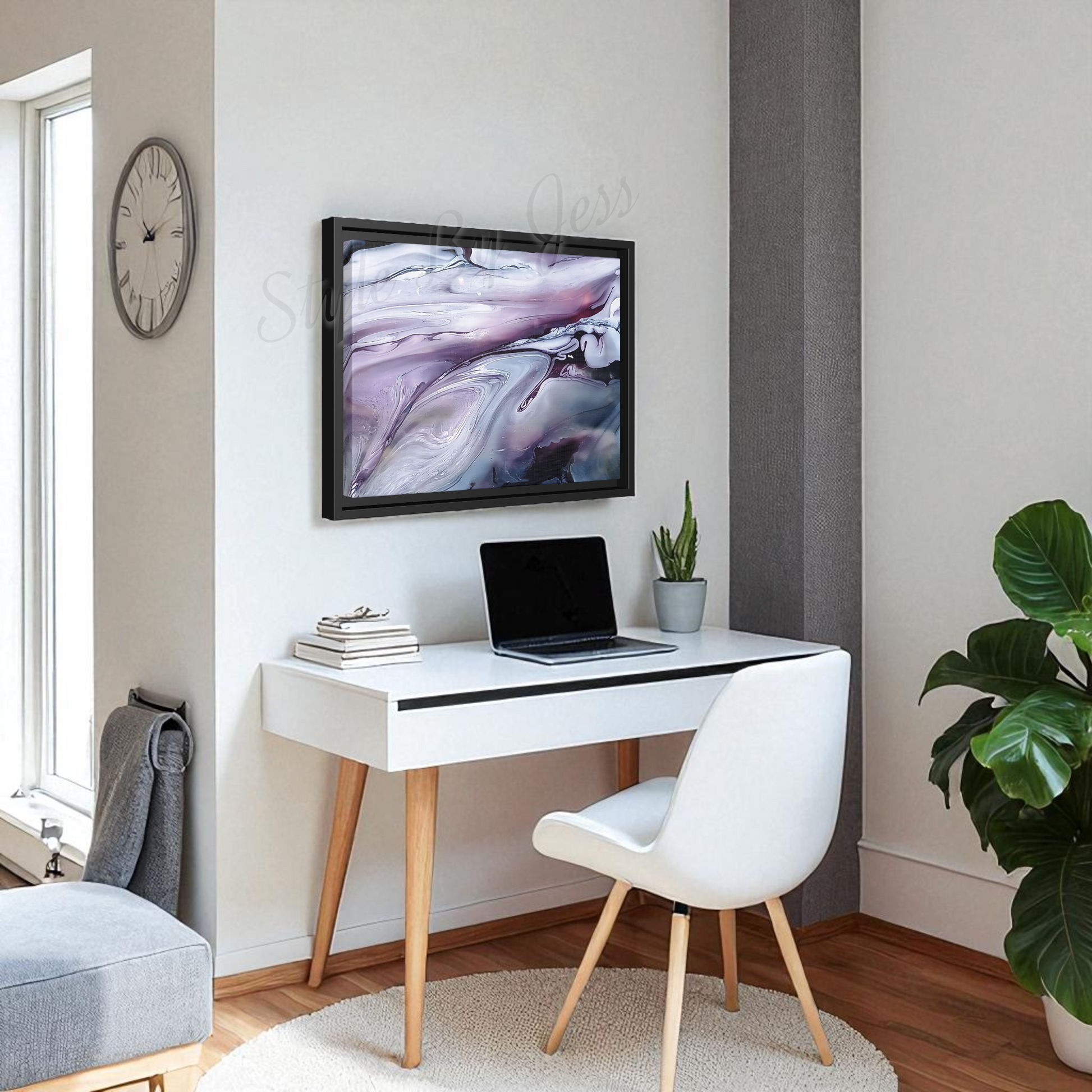 Modern home office with a white desk, laptop, Style By Jess canvas art piece on the wall and chair.