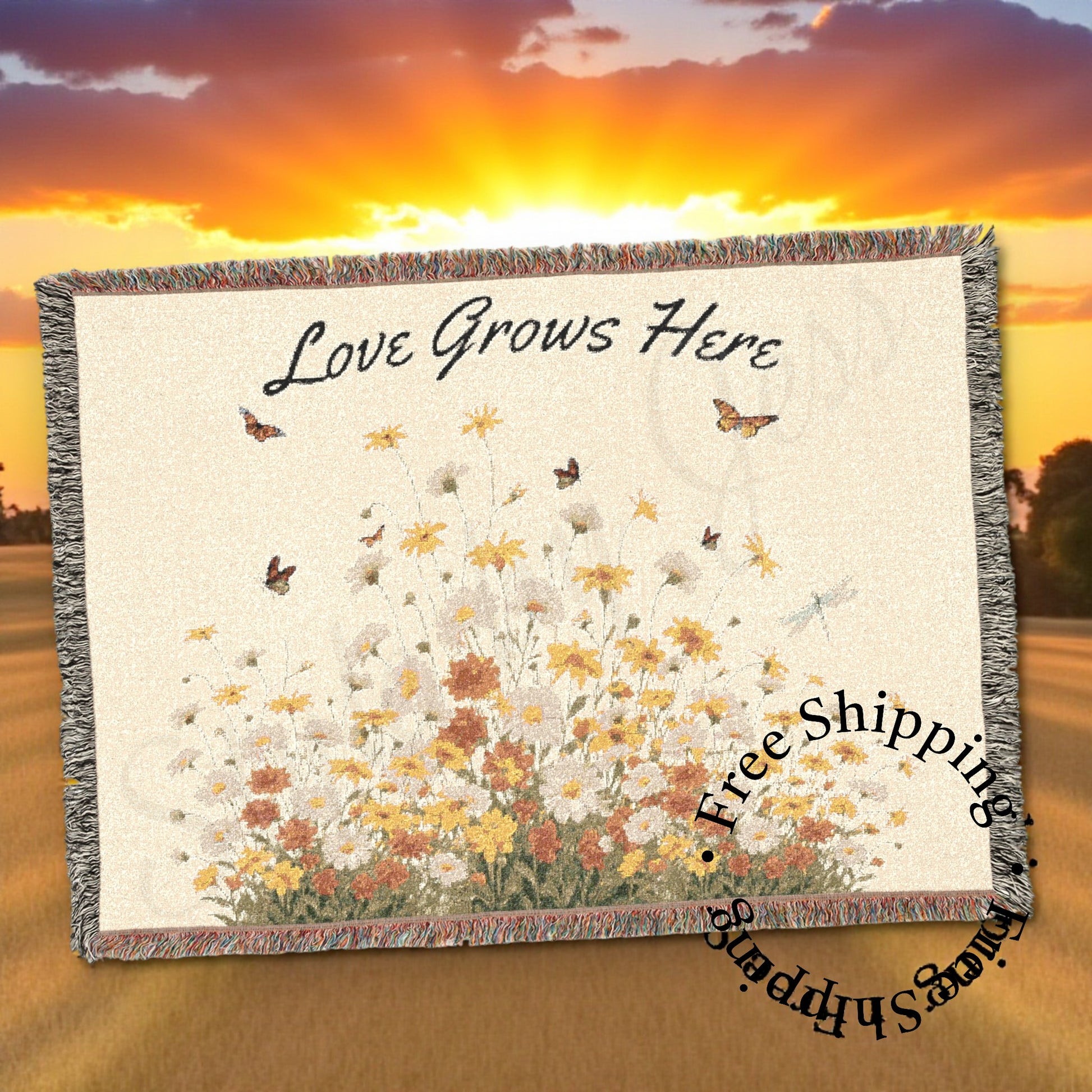 Blanket with floral design and 'Love Grows Here' text against a sunset background