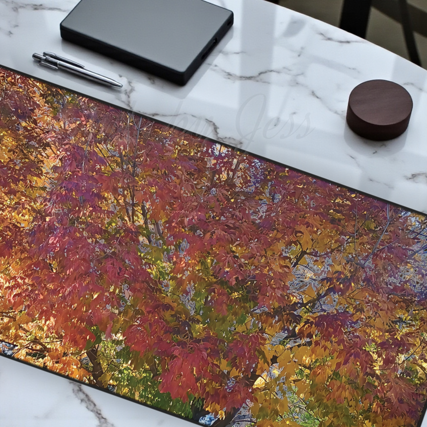 Desk mat with autumn leaf design on a marble surface